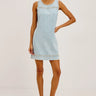Woman wearing a light blue denim dress on a white background