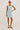 Woman wearing a light blue denim dress on a white background