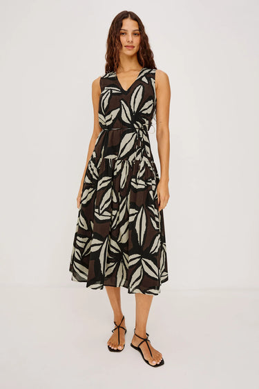 Woman wearing a sleeveless dress with leaf pattern on a white background