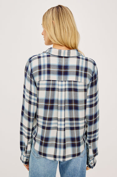 Woman wearing a blue and white plaid shirt on a plain background