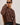 Person wearing a leopard print sweater against a plain background