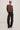 Person wearing a leopard print sweater and black jeans on a white background