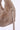 Close-up of a fluffy beige handbag with a strap on a white background