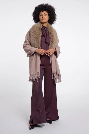 Woman wearing a fur stole over a purple outfit on a white background