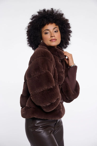 Woman wearing a brown fur jacket on a white background