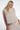 Woman wearing a white fluffy vest against a white background