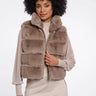 Woman wearing a brown faux fur vest on a white background