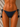 Navy blue bikini bottom with tassels on a beige background