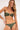 Woman wearing a green bikini against a white background
