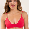 Woman wearing a red bikini top against a plain background