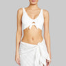 Woman wearing a white sleeveless top and skirt on a white background