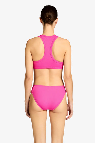Woman wearing a pink bikini set on a white background