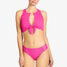 Woman wearing a pink bikini with gold buttons on a white background