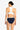 a woman wearing a white tank bikini and navy blue bikini bottoms