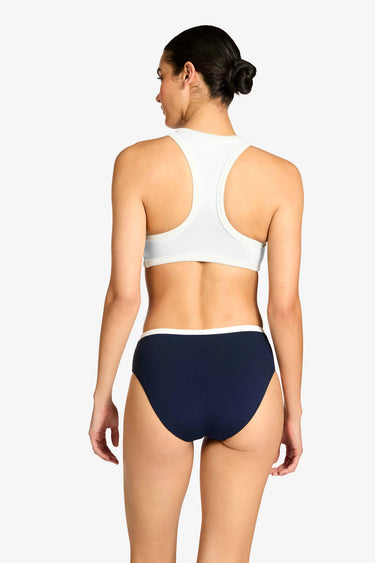 a woman wearing a white tank bikini and navy blue bikini bottoms