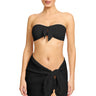 Woman wearing a black strapless top and black shorts on a white background