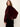 A woman modeling a plush, deep burgundy faux fur jacket with voluminous balloon sleeves, styled over a dark patterned top and black pants against a plain off-white background.