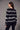 Black and white Fair Isle patterned sweater styled with slim black pants and black heels on a model.
