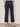 A woman wearing navy blue cropped pants on a neutral background