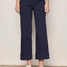 A woman wearing navy blue cropped pants on a neutral background