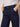 A woman wearing navy blue cropped pants on a neutral background