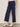 A woman wearing navy blue cropped pants on a neutral background