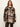 A woman modeling a brown, beige, and black plaid button-up coat over a dark brown top and dark brown leather pants, set against a plain off-white studio background.