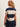 A woman wearing a rugby-reminicient striped shirt in navy and opal with ruched side details and a navy blue skirt