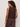 Woman wearing a brown sleeveless top and pants on a plain background