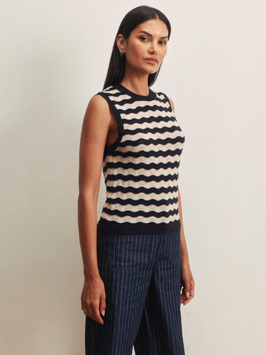 Model wearing a navy and ivory striped sleeveless knit sweater with navy pinstripe wide-leg pants.
