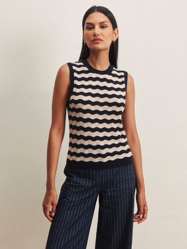 Model wearing a navy and ivory striped sleeveless knit sweater with navy pinstripe wide-leg pants.
