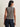 Model wearing a navy and ivory striped sleeveless knit sweater with navy pinstripe wide-leg pants.
