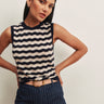 Model wearing a navy and ivory striped sleeveless knit sweater with navy pinstripe wide-leg pants.
