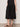 Person wearing a black skirt against a plain background
