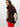 A model wearing a brown and beige diamond-patterned faux fur jacket with a high brown fur collar, paired with bright red pants, against a plain light gray background.