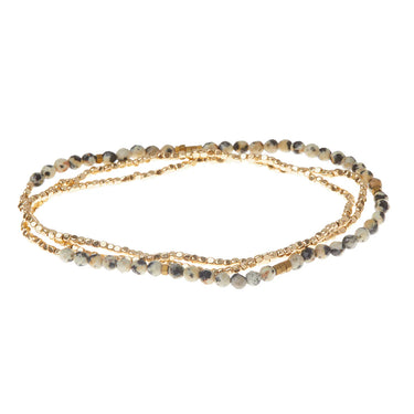 A delicate multi-strand necklace featuring gold-tone chains alongside small round beads in gray, brown, and black marbled stone, arranged in a circular loop on a white background.