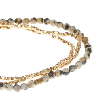 Set of beaded and gold bracelets on a white background