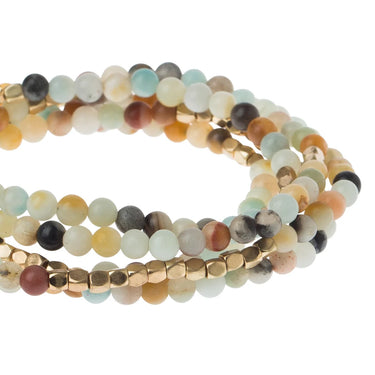 Stack of multicolored beaded bracelets on a white background