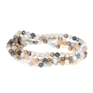Multistrand beaded bracelet with natural stone colors on a white background