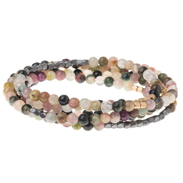 A set of three multi-strand beaded bracelets coiled together on a plain white background. The bracelets feature round and faceted beads in a mix of pastel pink, dusty purple, olive green, dark gray, and cream tones.