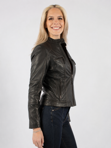 a woman wearing a black leather jacket with a vintage feel and zipper detailing with blue jeans on a white background