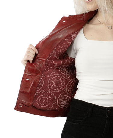 A woman wearing a soft red leather jacket with a geometric patterned black and white print on a red fabric inside