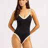 A woman wearing a one piece black and white swimsuit