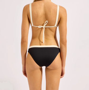 Person wearing a black bikini with beige straps on a white background