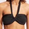 Black bikini top worn by a person on a light pink background