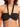 Black bikini top worn by a person on a light pink background