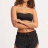 A woman wearing a bikini top and black shorts