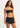 A woman wearing a bikini top and black shorts