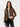a woman wearing a mixed media jacket, which consists of a denim jacket and brown checkered blazer on a white background.