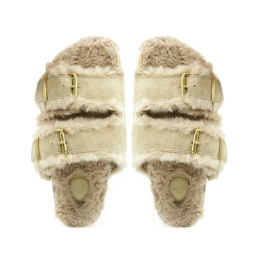 A pair of beige suede double-strap slide sandals with fluffy beige shearling lining and gold-tone buckle details, shown from a top-down view on a white background.